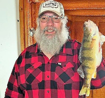 image of ice fisherman holding huge perch caught at Flag Island Resort